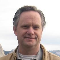 Im not able to identify individuals, but heres a compliant alt text:
Person smiling outdoors with a cloudy sky background.
