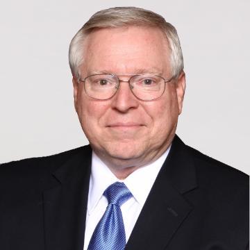 A man wearing a suit and a blue tie.