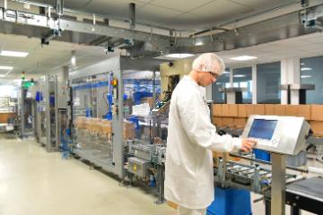 Worker in biopharmaceutical manufacturing plant at a computer