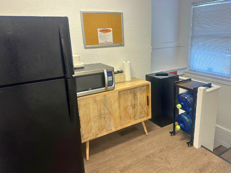 The Grad Hub kitchenette with a fridge, microwave, and storage area. 