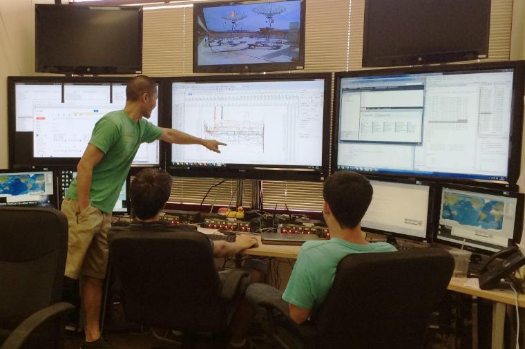 Students in SCUs Mission Control Lab sit in front of a bank of six large monitors and other equipment