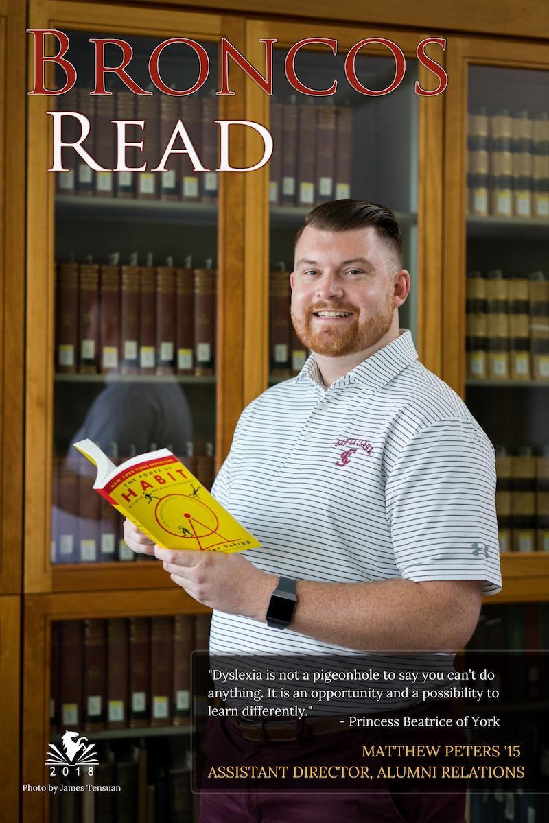 Matt standing and holding a book