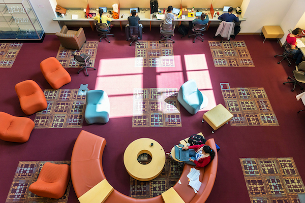 Students studying on the librarys colorful lower level